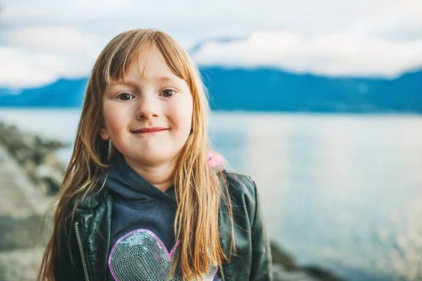 Açık siyah deri ceket giyiyor göl kenarında oynarken küçük 5 yaşındaki çocuk kız portresi. — Stok fotoğraf