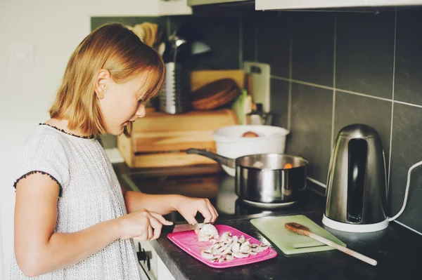 Cute little girl cooking vegetable lunch for the family, kid helping in the kitchen — Stock Photo, Image