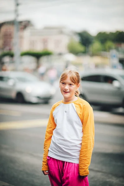 Retrato ao ar livre de uma menina adolescente bonita em uma cidade, vestindo camiseta de beisebol de manga longa amarela e branca e calças rosa brilhantes — Fotografia de Stock