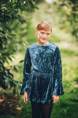 Açık mavi kadife playsuit giyen güzel küçük 10 yaşındaki kız portresi