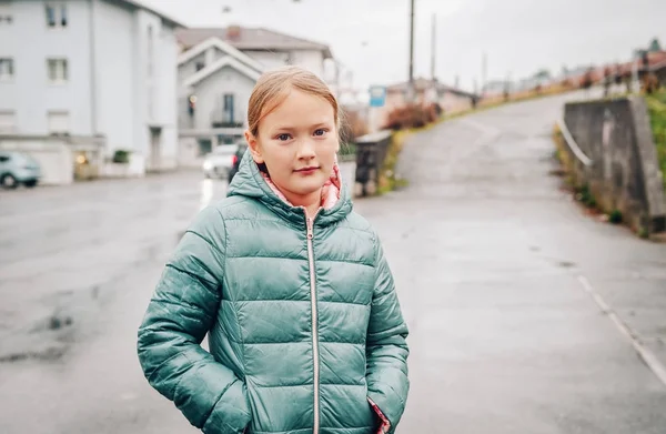 Außenporträt eines hübschen 8-jährigen Mädchens an einem regnerischen Tag mit grüner Jacke — Stockfoto