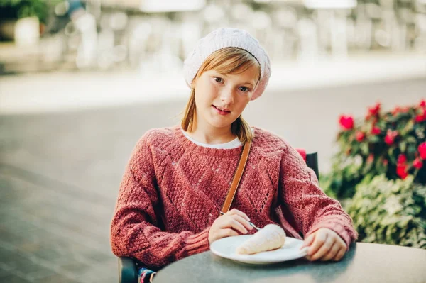 Красивая маленькая девочка отдыхает в кафе, ест сладкий торт — стоковое фото