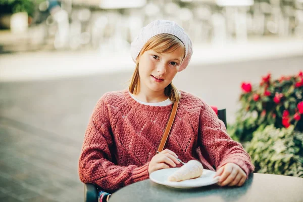 Niña bonita descansando en la cafetería, comiendo pastel dulce — Foto de Stock