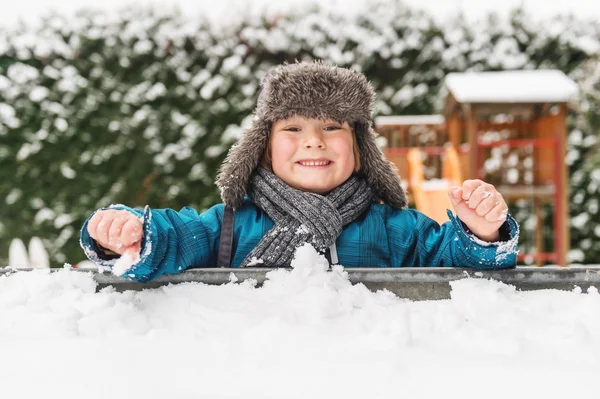 可爱的孩子男孩玩耍在沙盒中满了雪，穿着保暖帽 — 图库照片