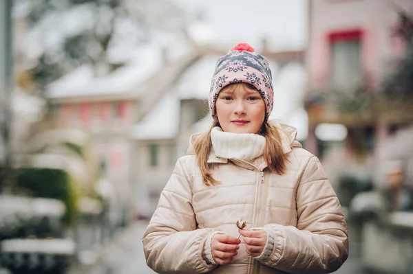 Vinter porträtt av lilla vackra flicka klädd varm beige jacka och mössa — Stockfoto