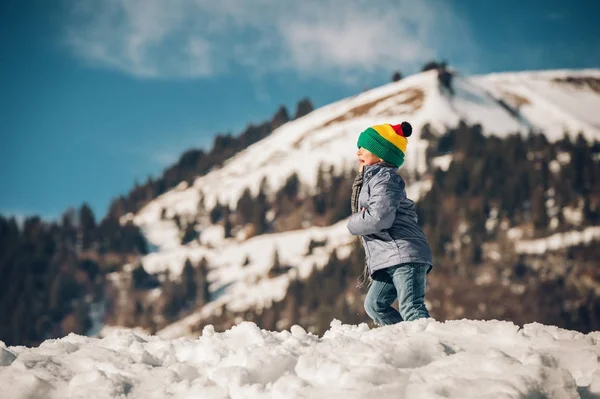 Liten pojke klättring de snow hill, vintersemester med barn. Bild tagen i Valais, Schweiz — Stockfoto