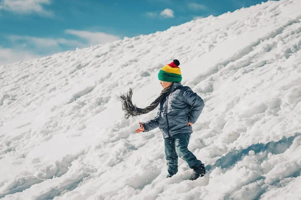 Liten pojke klättring de snow hill, vintersemester med barn. Bild tagen i Valais, Schweiz — Stockfoto