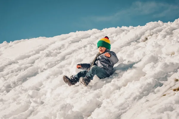Liten pojke klättring de snow hill, vintersemester med barn. Bild tagen i Valais, Schweiz — Stockfoto
