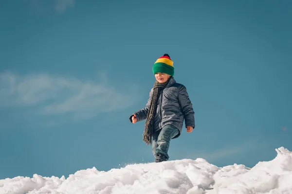 Liten pojke klättring de snow hill, vintersemester med barn. Bild tagen i Valais, Schweiz — Stockfoto