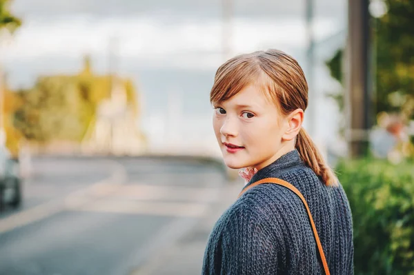 Außenporträt eines süßen, über die Schulter schauenden Mädchens in lila Strickjacke — Stockfoto