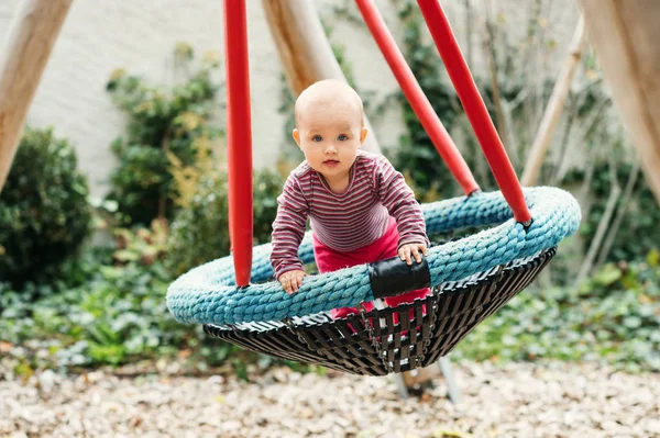 Μωρό κορίτσι Διασκεδάζοντας στο πάρκο, παιδί 9-12 μηνών που παίζει στη μεγάλη ταλάντευση, καλοκαιρινή παιδική χαρά, δραστηριότητες για παιδιά — Φωτογραφία Αρχείου