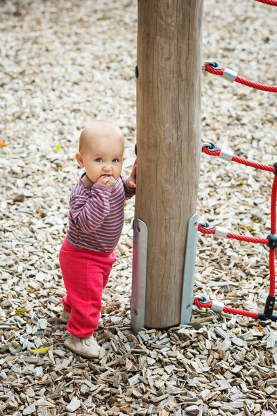 Retrato ao ar livre de adorável bebê menina se divertindo no parque infantil, bonito pouco 9-12 meses criança brincando ao ar livre — Fotografia de Stock