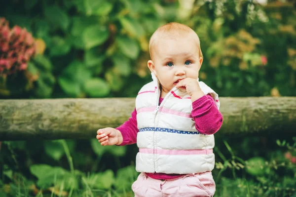 Retrato ao ar livre de adorável menina de 9-12 meses de idade brincando no parque, vestindo aquecedor de corpo branco — Fotografia de Stock