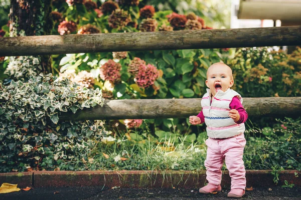 Retrato ao ar livre de adorável menina de 9-12 meses de idade brincando no parque, vestindo aquecedor de corpo branco — Fotografia de Stock