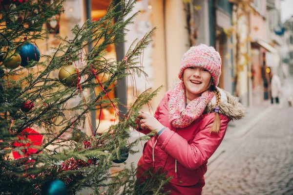 Menina feliz brincando com árvore de Natal nas ruas da antiga cidade europeia, viagem de férias com crianças, imagem tirada em Lausanne; Suíça — Fotografia de Stock