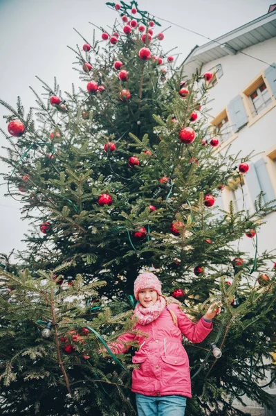 Menina feliz brincando com árvore de Natal nas ruas da antiga cidade europeia, viagem de férias com crianças, imagem tirada em Lausanne; Suíça — Fotografia de Stock