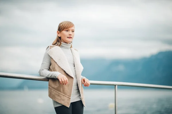 Outdoor Portret van vrij klein meisje rusten door het meer op een bewolkte dag, foto genomen in Lausanne, Zwitserland — Stockfoto