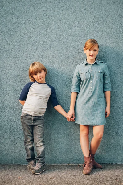 Outdoor portrait of 2 fashion kids posing against blue background, full length portrait — Stock Photo, Image