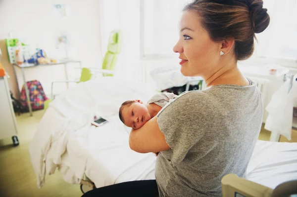 Happy young mother with newborn baby in hospital after giving birth — Stock Photo, Image