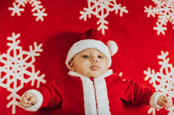 Retrato de Natal de bebê recém-nascido adorável vestindo roupa de Papai Noel, deitado em cobertor de floco de neve, vista superior . — Fotografia de Stock