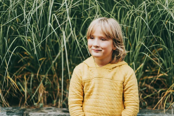 Retrato de moda al aire libre de lindo niño con sudadera amarilla con capucha — Foto de Stock