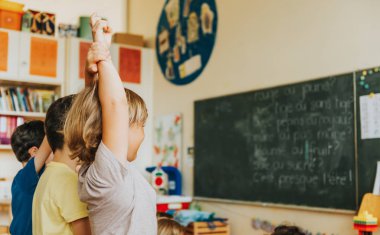 Sınıf, ders, arkadan görünüm çocuk yükselterek yandan konsantre 4-5 yaşındaki çocuklarda