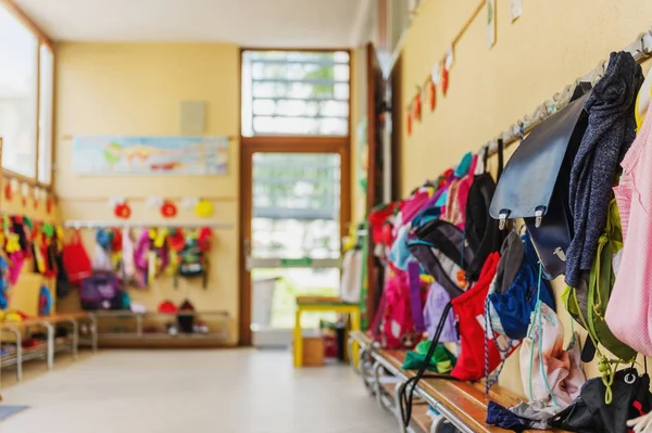 Salão vazio na escola, mochilas e sacos em ganchos, sala de recreação brilhante — Fotografia de Stock