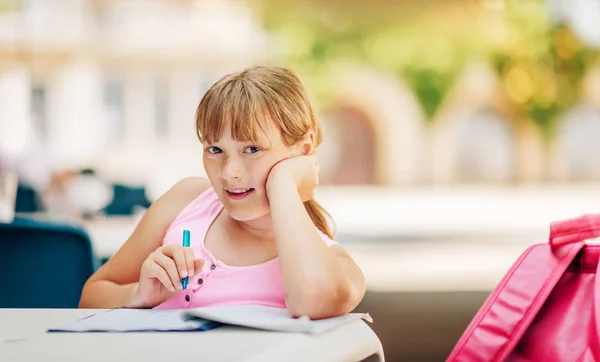 Cute kid girl doing school homework outside, home schooling, education for children, back to school concept — Stock Photo, Image