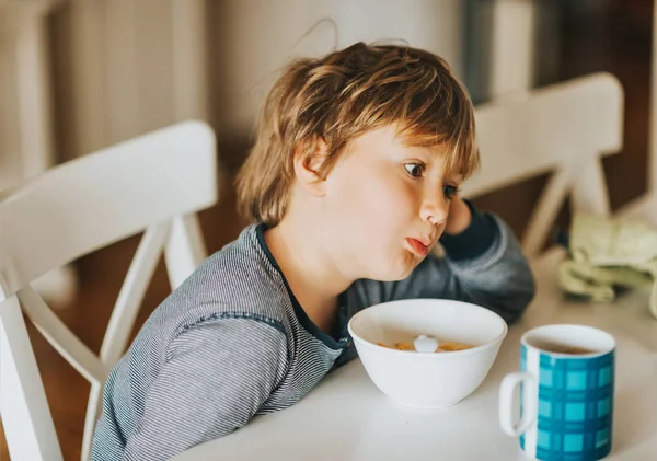 Søt Liten Gutt Som Spiser Korn Med Melk Til Frokost – stockfoto