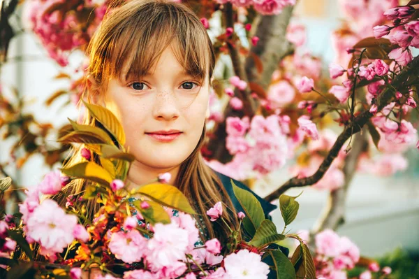 花で日本の桜の花の間に立って かわいい女の子の露天の肖像画 — ストック写真