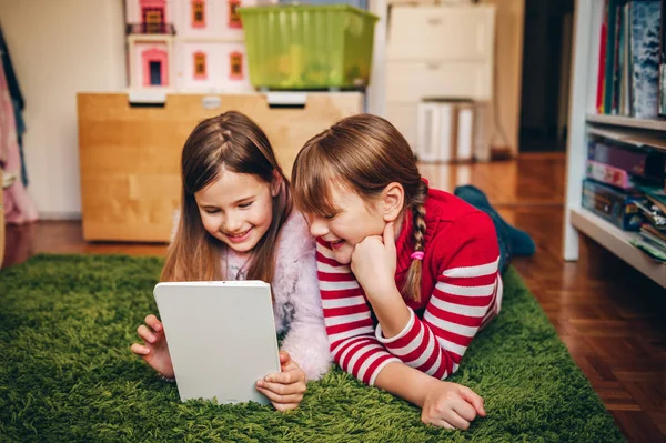 Duas Meninas Bonitos Jogando Tablet Digital Colocando Tapete Verde Quarto — Fotografia de Stock