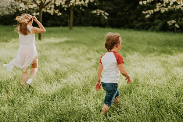 Duas Crianças Adoráveis Brincando Juntas Jardim Primavera Dia Muito Ventoso — Fotografia de Stock