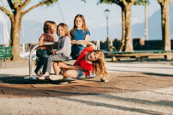 Skupina Čtyř Děti Baví Hřišti Stylový Děti Hrají Kolotoči Parku — Stock fotografie