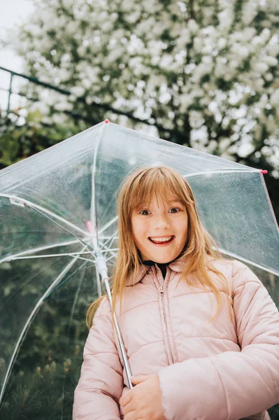 透明な傘 春の陽気で愛らしい少女の面白い肖像画 — ストック写真