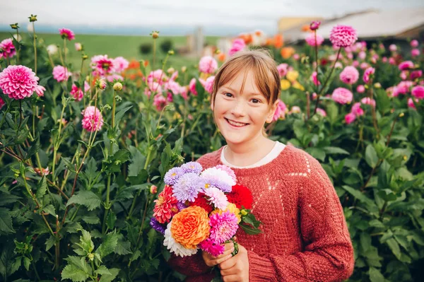 かわいい女の子ダリア花のカラフルな花束を持ってファッション プルオーバーを着ての屋外のポートレート — ストック写真