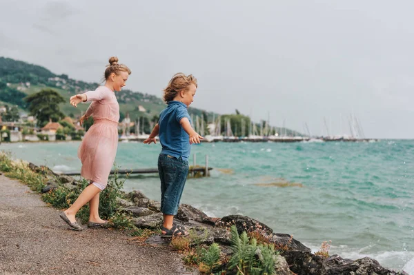 Dulces Niños Jugando Junto Lago Día Muy Ventoso Bajo Lluvia — Foto de Stock