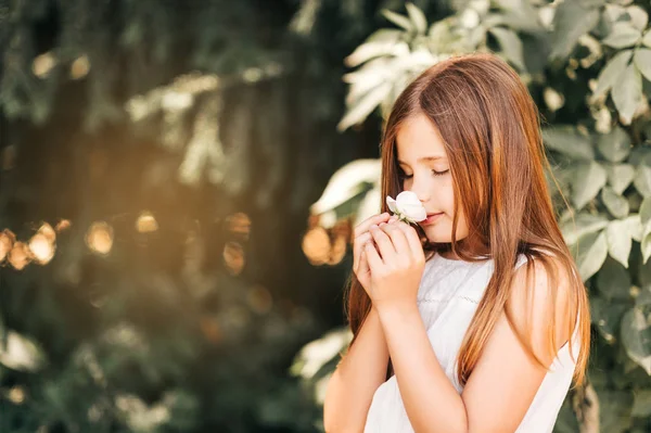 白いバラの花と愛らしい少女の屋外のポートレート — ストック写真