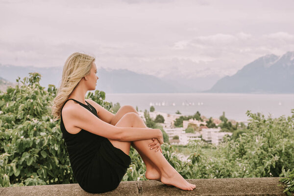 Portrait of young blond woman resting outdoors in Lavaux vineyards, Switzerland