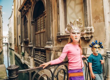 Ünlü Venedik Maske ile oynayan iki çocuklar. Küçük kız ve erkek Venedik, İtalya ziyaret etti. Küçük turistler Hatıra karnaval maskesi takmış