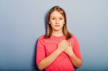 Sevimli küçük kız pembe elbise, mor arka planı poz, kalp yanındaki elele stüdyo çekim