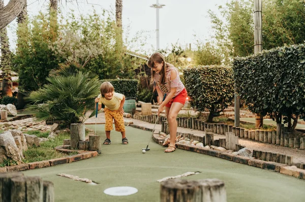 Mini golf oynayan çocuklar yaz tatili zevk iki komik çocuklar grup