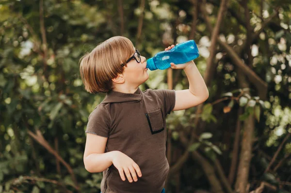 スマートで面白い少年野外で遊ぶ 着て眼鏡 水のボトルを保持しています — ストック写真