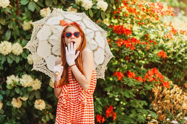 Komik küçük kız giyiyor şemsiye playsuit, kalp şeklinde güneş gözlüğü, beyaz eldiven, stilize dantel şemsiye, retro tutan görüntü