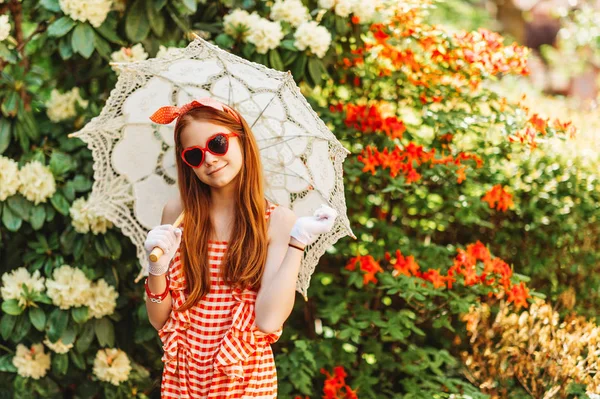 Komik küçük kız giyiyor şemsiye playsuit, kalp şeklinde güneş gözlüğü, beyaz eldiven, stilize dantel şemsiye, retro tutan görüntü