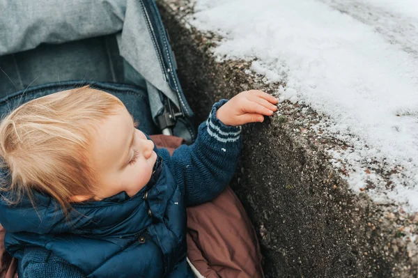Cute Toddler Boz Sitting Stroller Touching First Snow — Stock fotografie