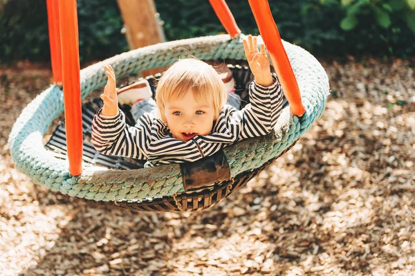 幼児の女の子は公園で楽しみ 3歳の子供は大きなスイング 遊び場 子供のための活動で遊んでいます — ストック写真