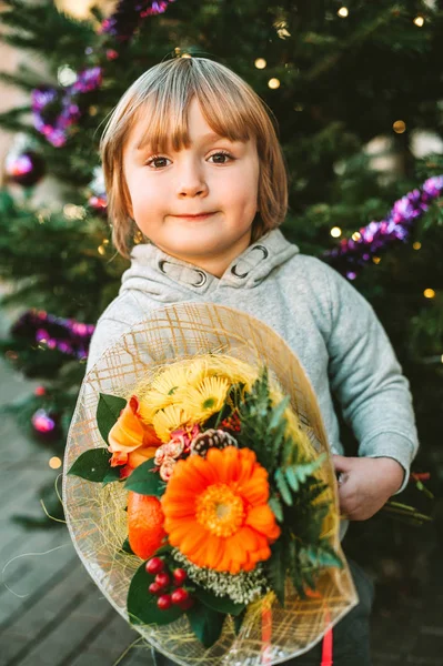 Retrato Menino Bonito Segurando Buquê Flores Natal Lado Árvore Natal — Fotografia de Stock