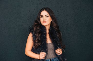 Parlak makyajlı ve uzun siyah saçlı güzel bir genç kadının portresi.