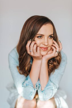 Uzun saçlı, mavi kot ceket giyen güzel bir kadının portresi.