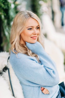 Sarı saçlı, mavi kazaklı güzel bir kadının kış portresi.